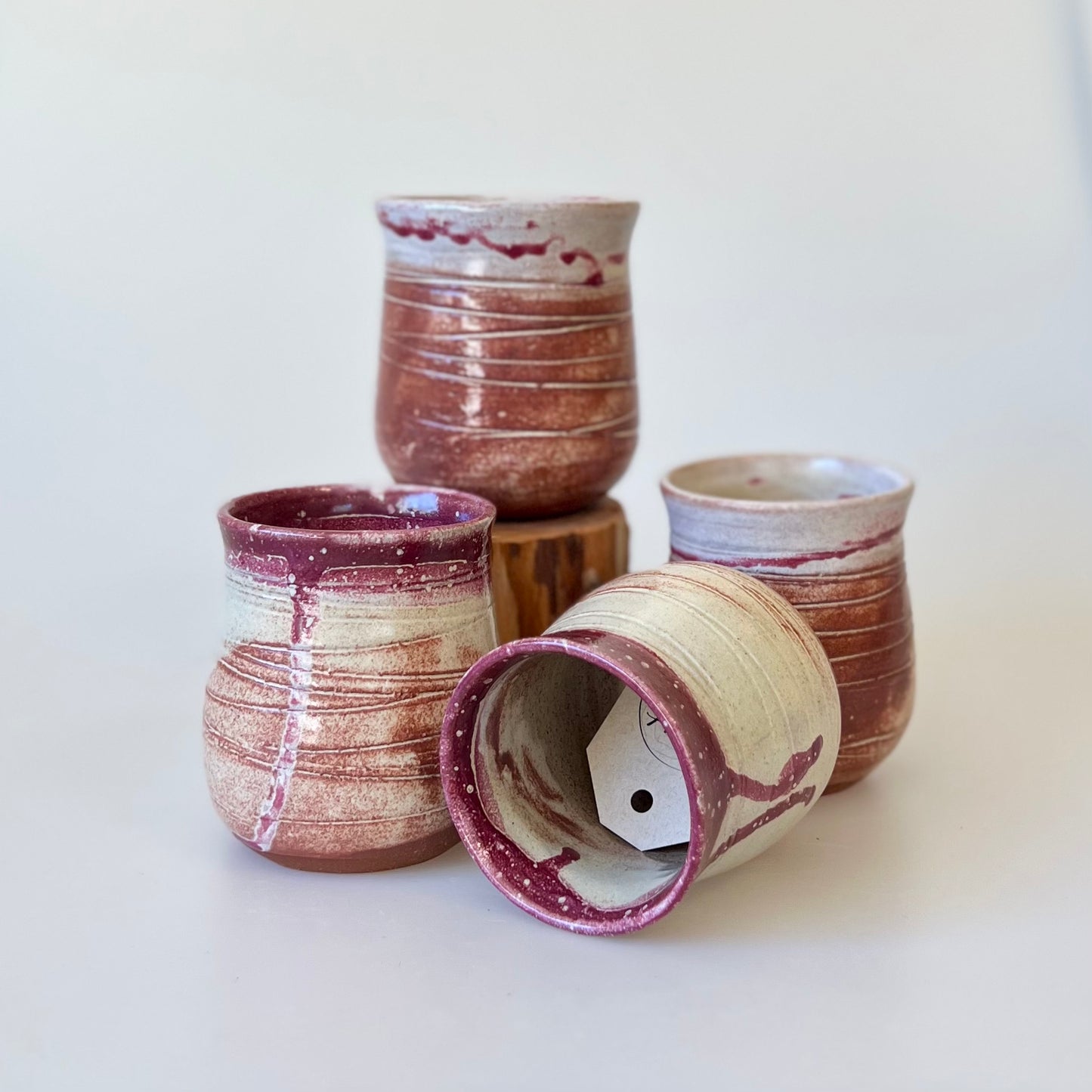 four small stemless red clay ceramic round wine tumblers