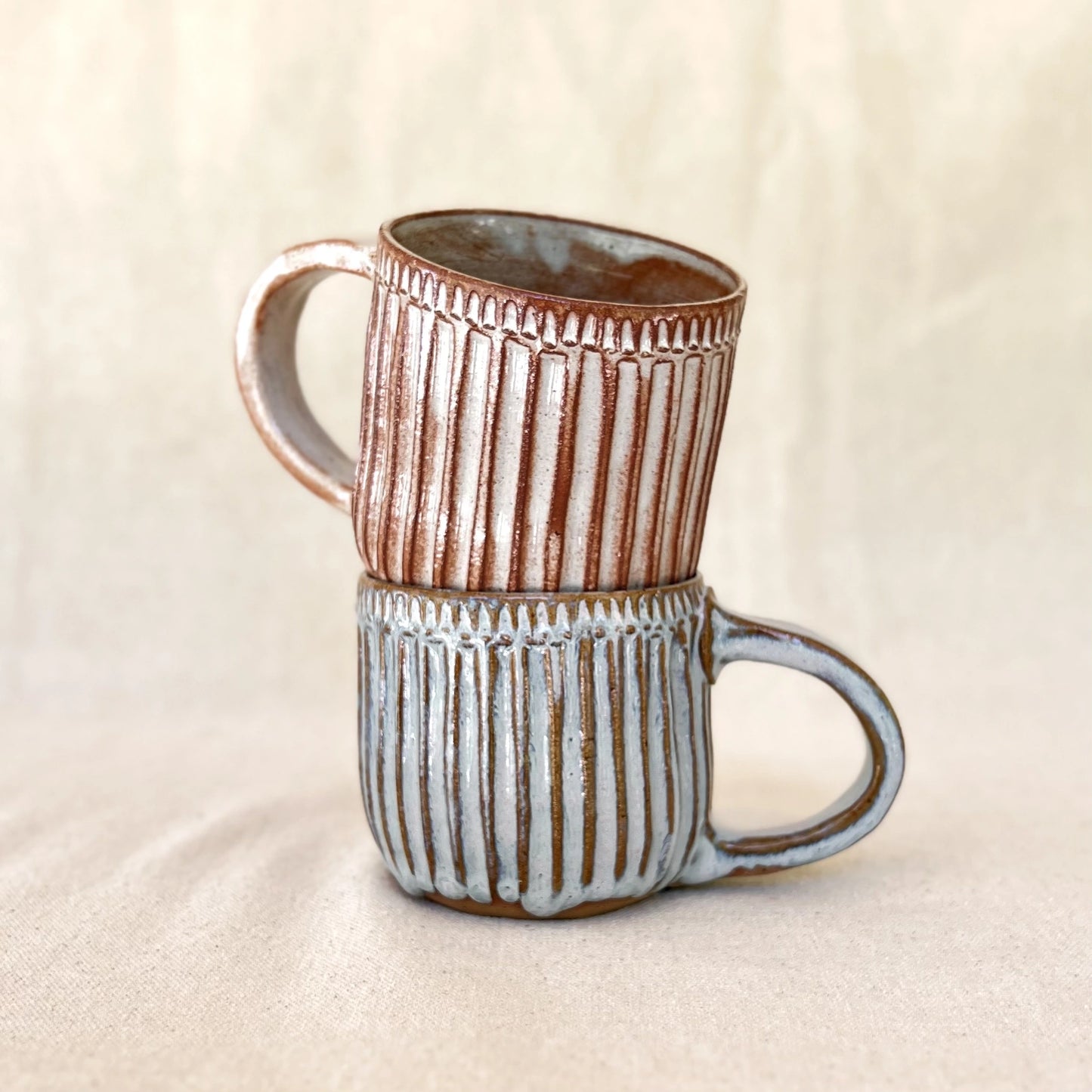 One red and one blue large ceramic carved coffee mugs