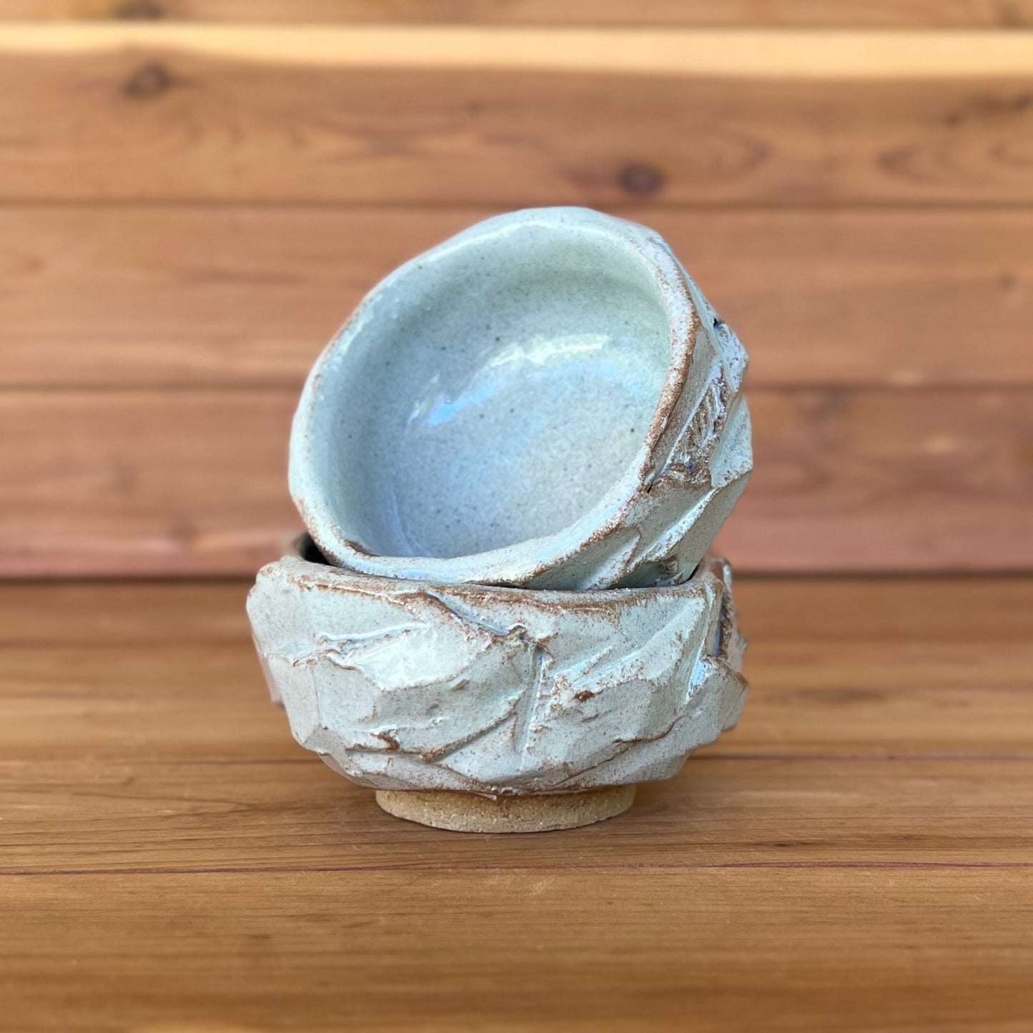 two little hand carved Japanese kurinuki pottery cups with a blue gray glaze