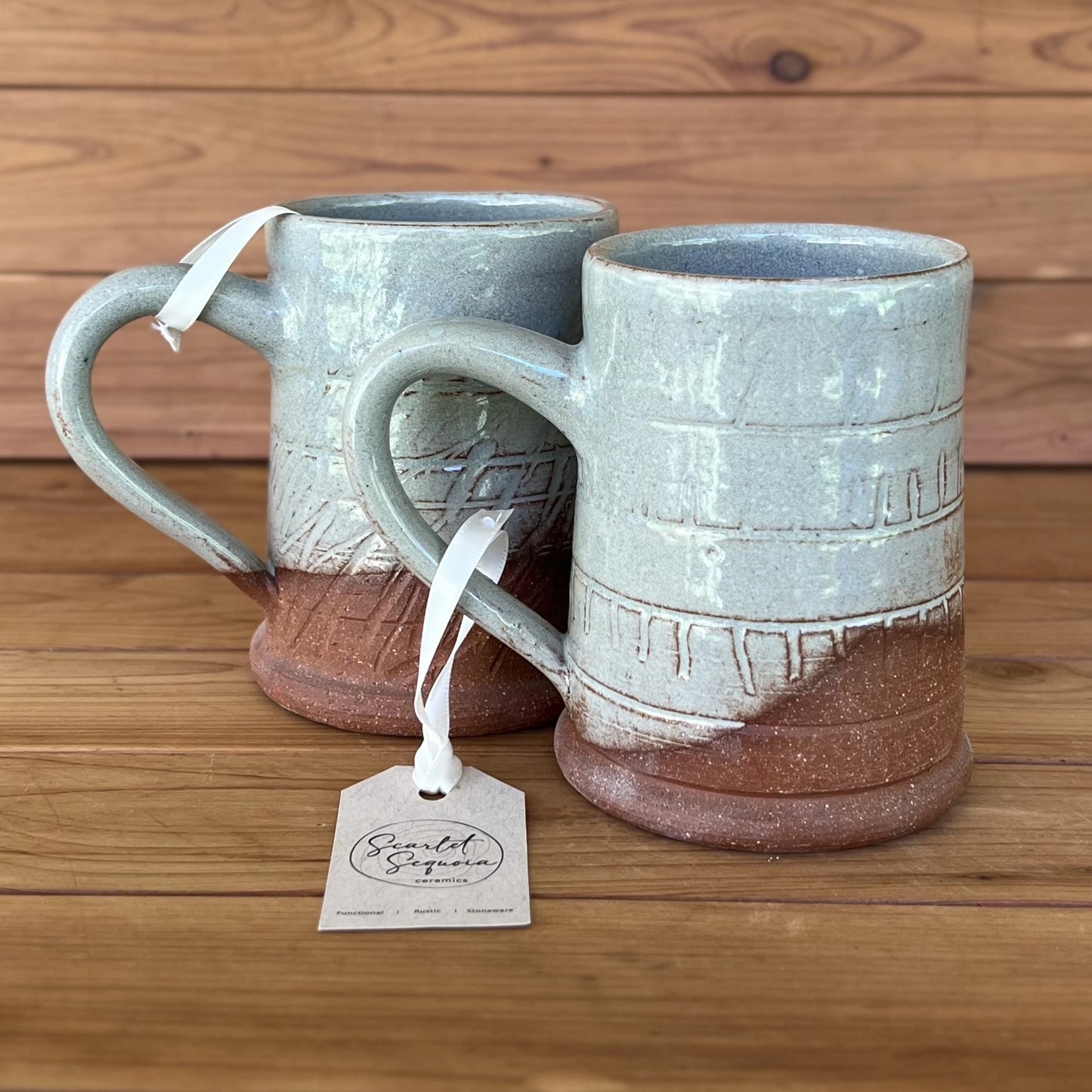 Pair of carved red stoneware ceramic coffee mugs with a blue grey glaze