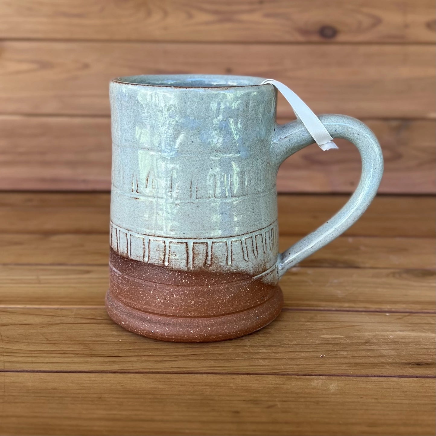 One carved red stoneware ceramic coffee mug with a blue grey glaze