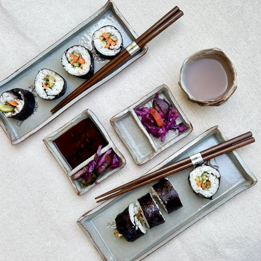 Blue and red sushi set with sushi, soy sauce, and kurinuki cup