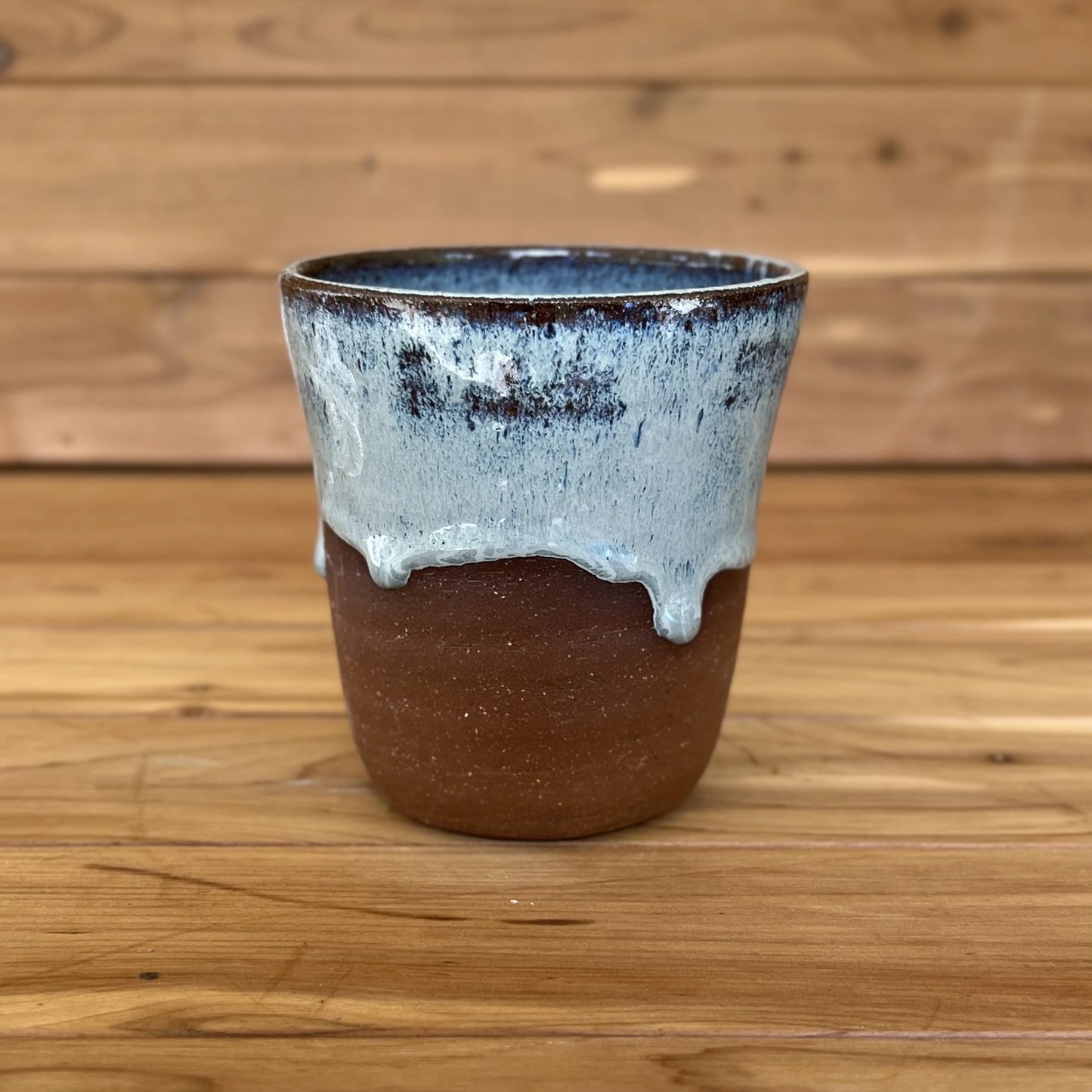 One red stoneware tumbler in asymmetrical blue glaze