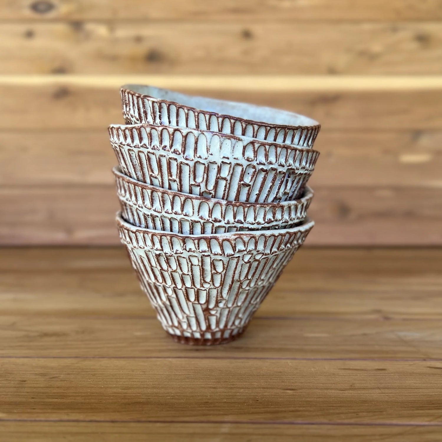 Stack of small red carved ceramic tumblers