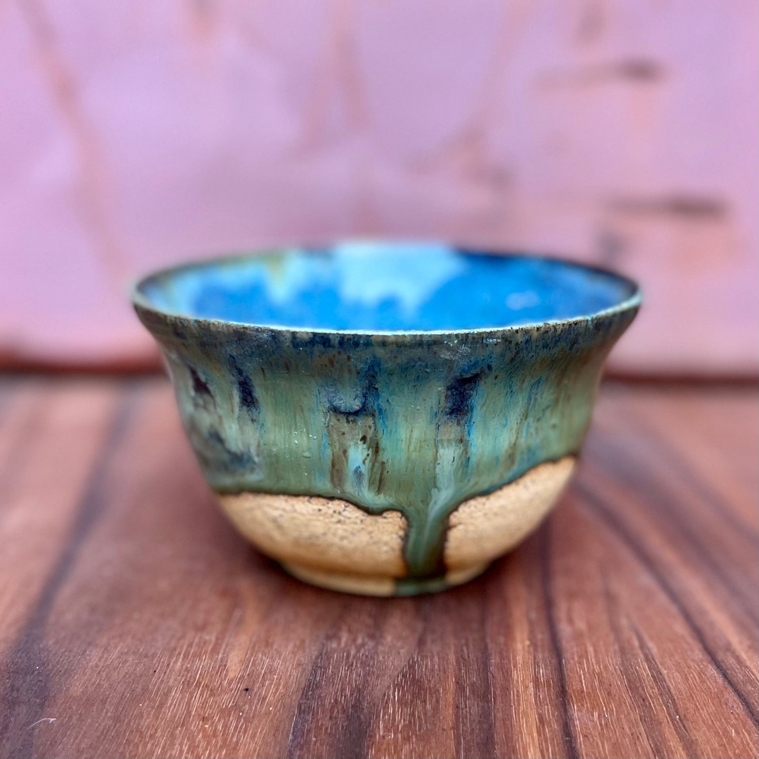 Speckled ceramic pottery bowl with a blue and green drip glaze