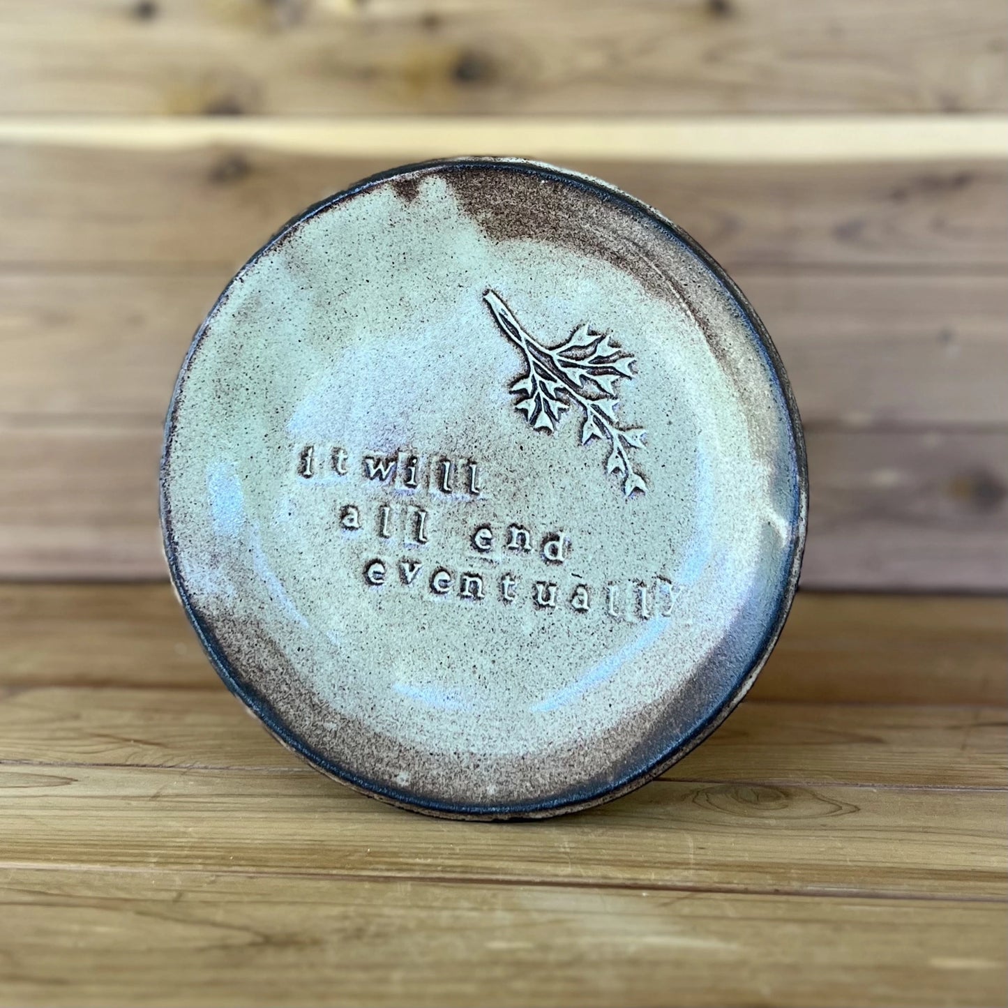 black ceramic plate with saying "it will all end eventually" and botanical stamp