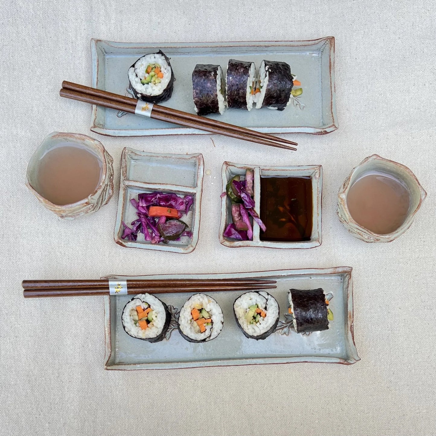Blue and red sushi set with sushi, soy sauce, and kurinuki cups