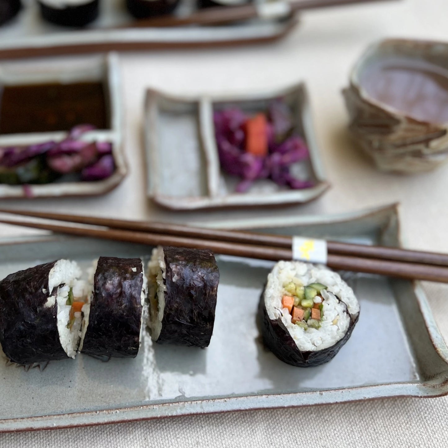 Rustic ceramic blue sushi set with sushi, soy sauce, and kurinuki cups