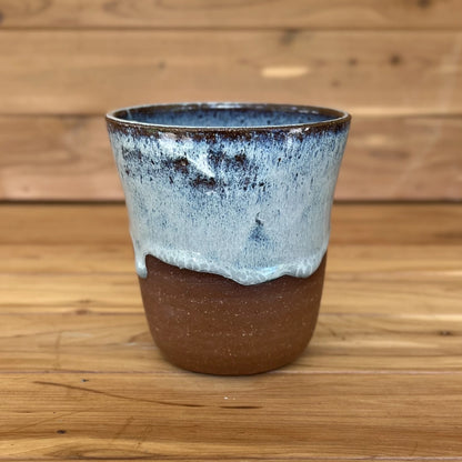 One red stoneware tumbler in asymmetrical blue glaze