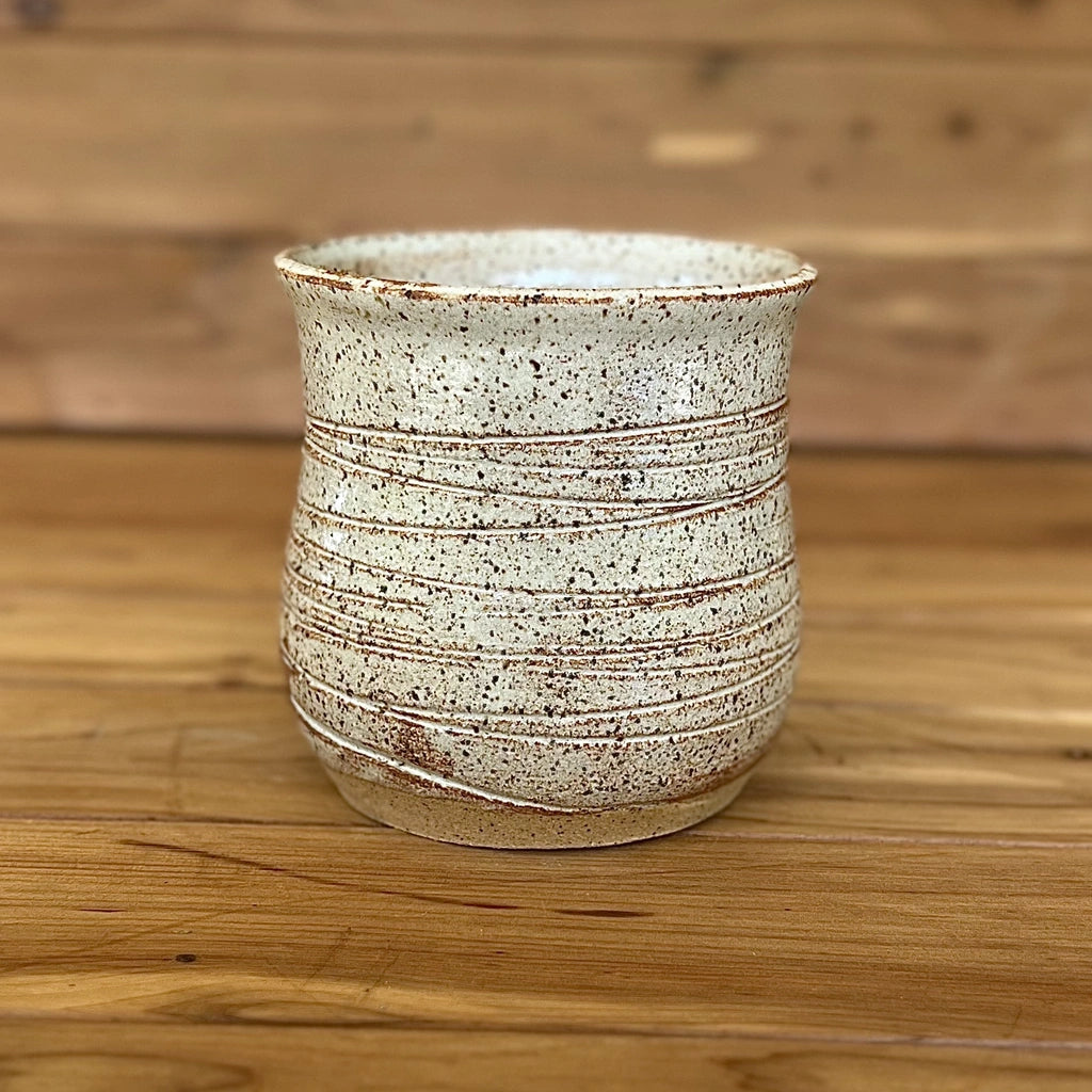 Speckled clay cup with no handle and a white and red glaze