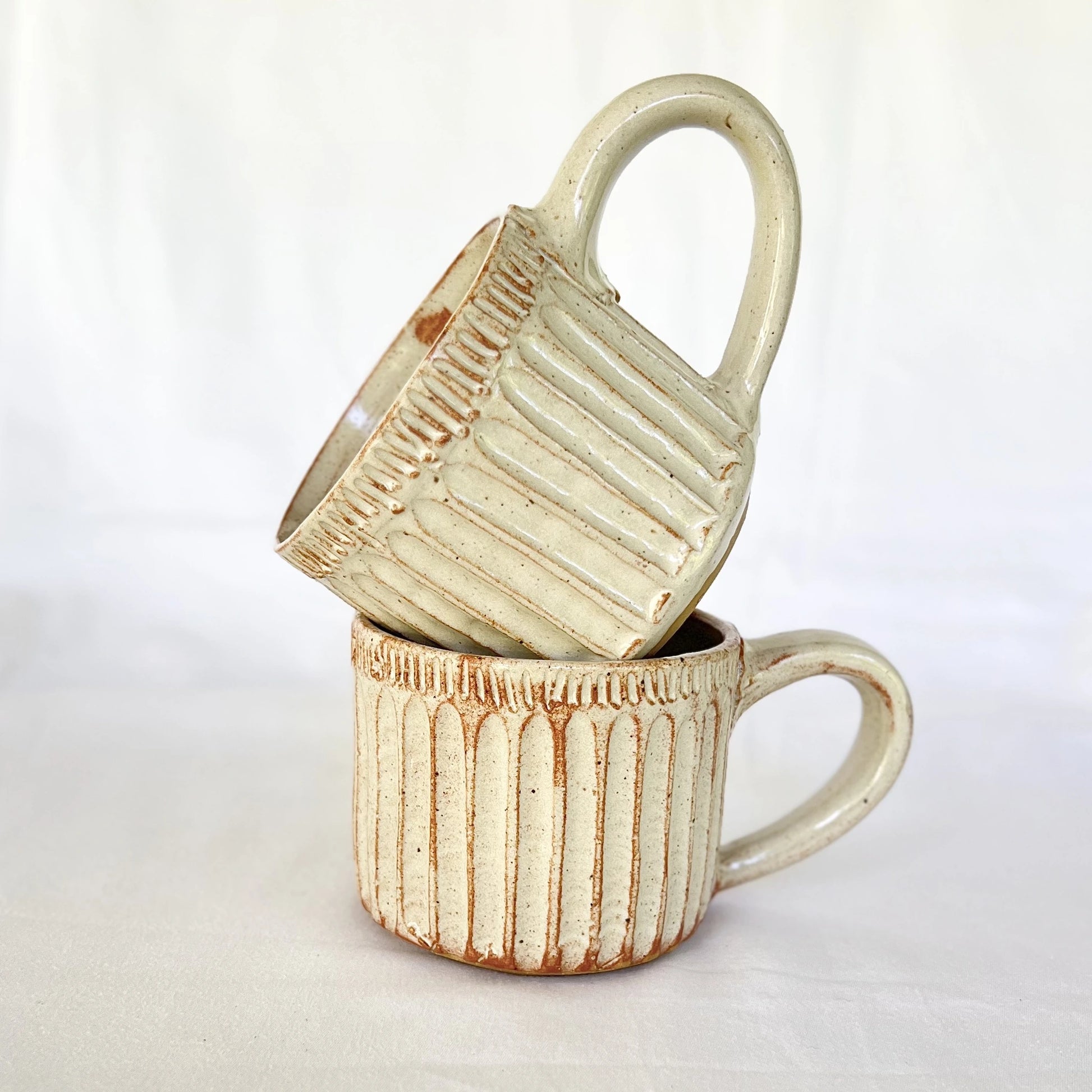 Stack of rustic white speckled ceramic cappuccino mugs