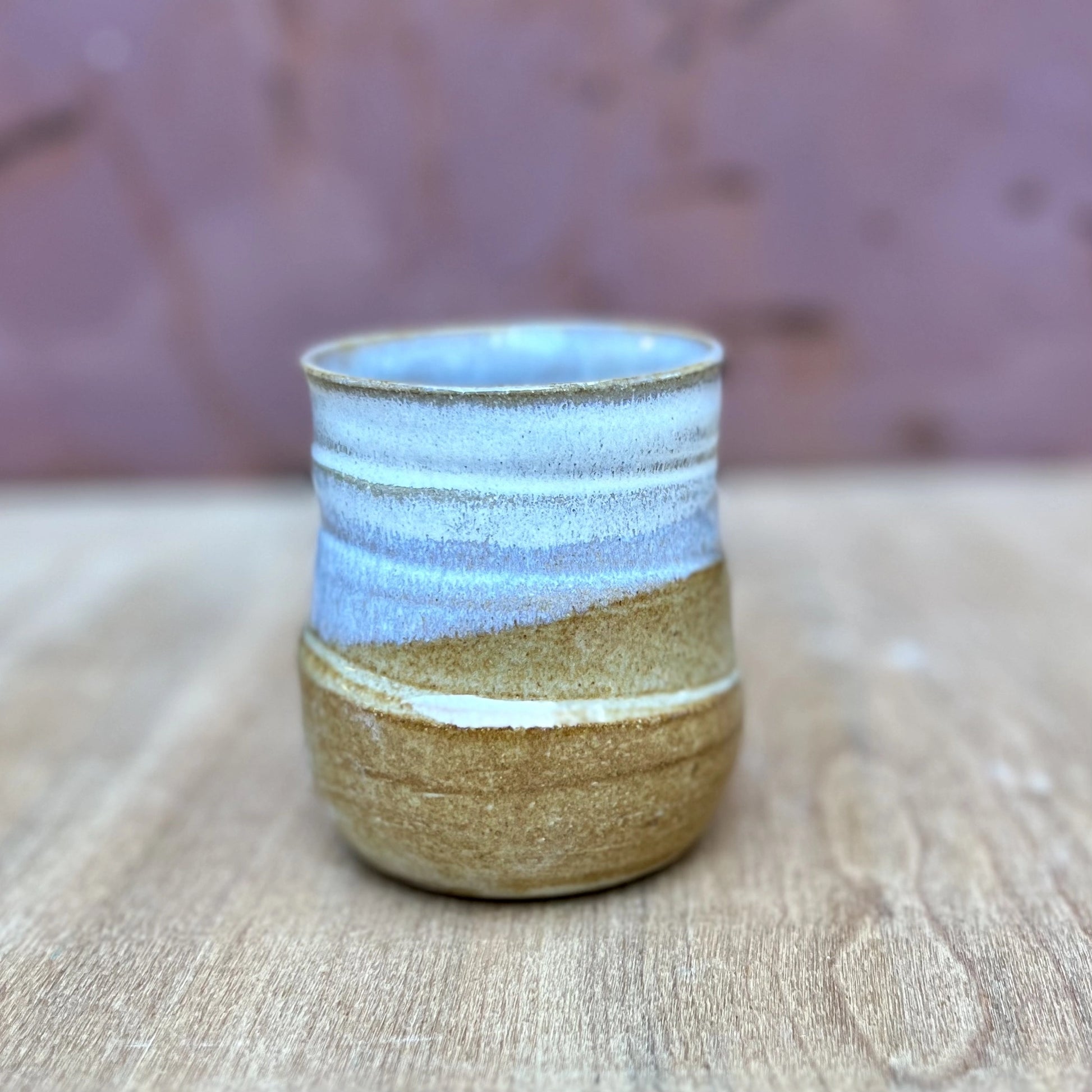 small wheel thrown ceramic tumbler with a marigold and white glaze