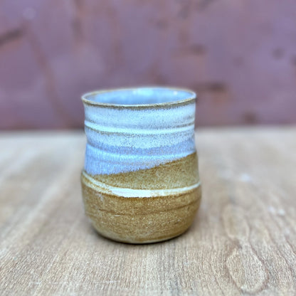 small wheel thrown ceramic tumbler with a marigold and white glaze