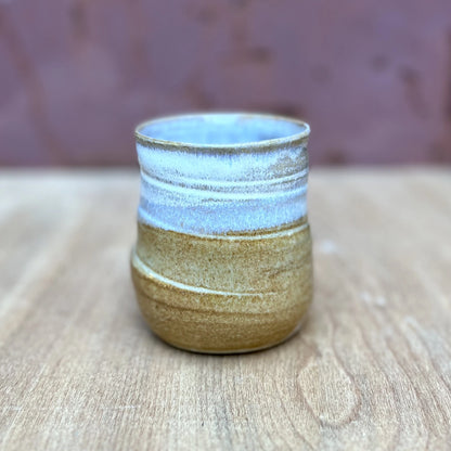 small wheel thrown ceramic tumbler with a marigold and white glaze