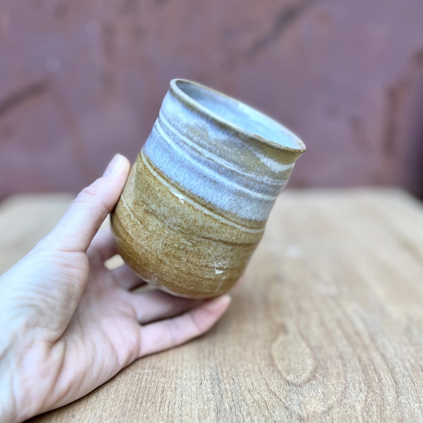 small wheel thrown ceramic tumbler with a marigold and white glaze